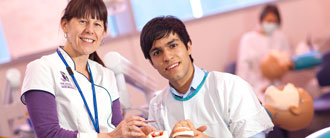 Two graduates examining teeth